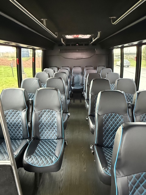 Shuttle bus interior with diamond-stitched blue and black leather seats