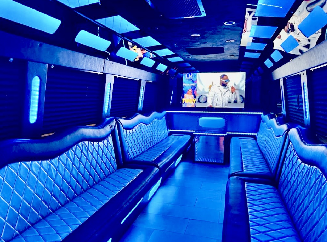 The Luxe party bus interior with blue LED lighting, diamond-stitched seating and flat screen TV