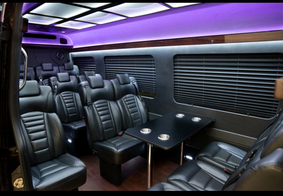 Executive Sprinter Van interior with leather seats and purple LED lighting