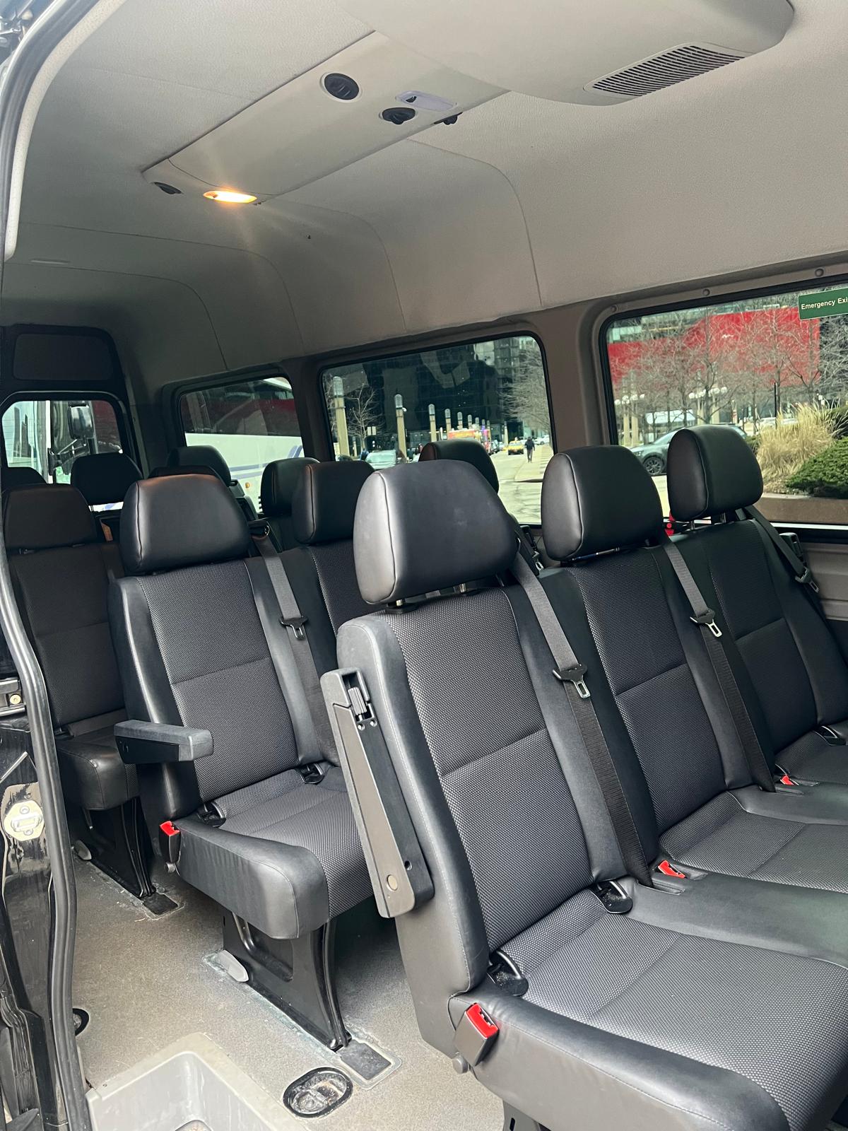 13-Passenger Sprinter interior with charcoal seats and city views through large windows